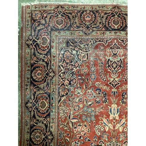 386 - A Persian style red ground rug, with blue stylized borders, with some all over general wear, 132 cm ... 