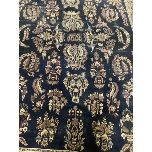 384 - A large Persian style blue ground rug, notable all over wear 255 cm x 404 cm