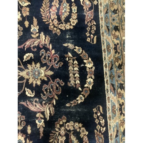 384 - A large Persian style blue ground rug, notable all over wear 255 cm x 404 cm