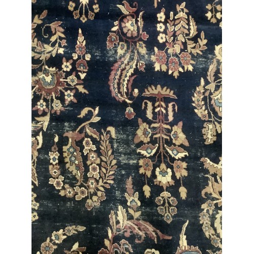 384 - A large Persian style blue ground rug, notable all over wear 255 cm x 404 cm