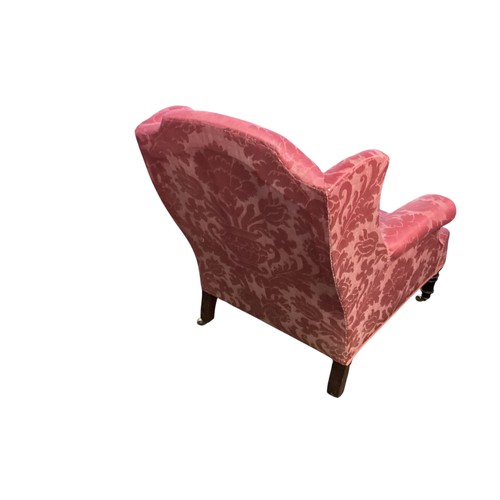 561 - Red upholstered wing back arm chair to turned legs and brass castors 88 cm H 76 cm W x 68n cm D at b... 