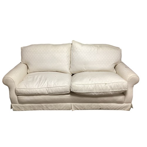 575 - A cream two seater sofa, as found