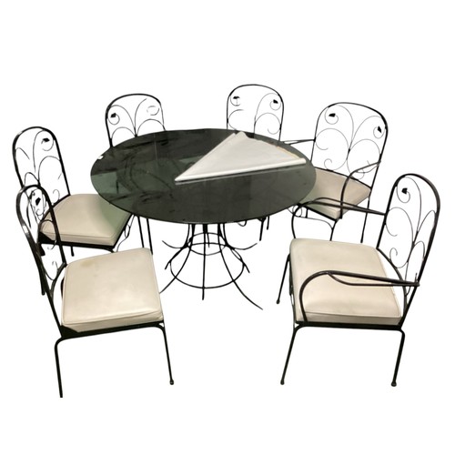 569 - A circular black glass conservatory table  with 6 matching chairs and cushions