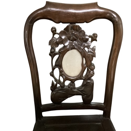 576 - A pair of hardwood oriental style chairs, with solid seat and carved back, and central oval stone pa... 