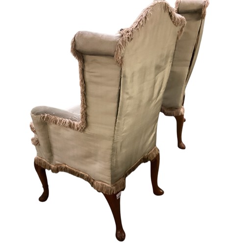 501 - A pair of C18th upright high winged back armchairs, upholstered in a faded light green silk, on carv... 