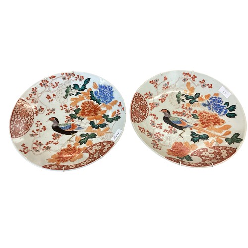 101 - A pair of Oriental chargers, Japanese Kutani style, decorated in the Imari palette, exotic birds and... 