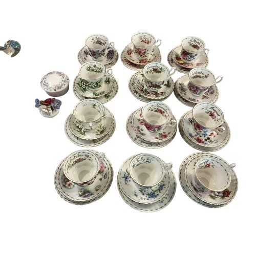 263 - A set of Royal Albert Bone china cups, saucers and plates, illustrated with a month for each set