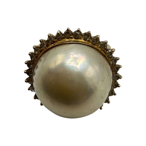 10 - An 850 marked .pearl and diamond dress ring. Central button pearl with a surround of single cut diam... 