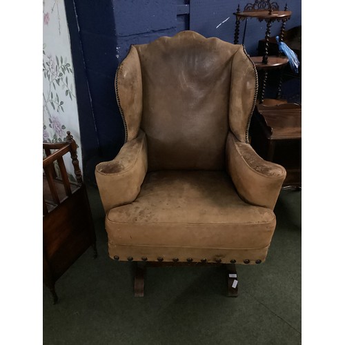 566 - A good, very worn, leather studded wing back rocking (sprung) arm chair, 106 cm H. Condition: much a... 