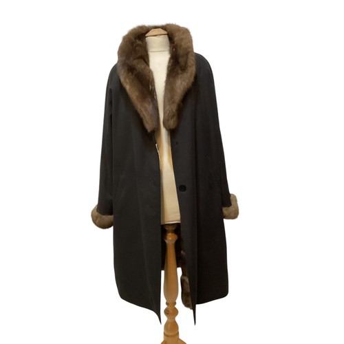 79 - A black 3/4 length black raincoat with  fur lining and fur collar and cuffs.