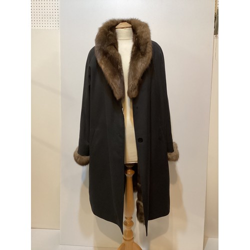 79 - A black 3/4 length black raincoat with  fur lining and fur collar and cuffs.