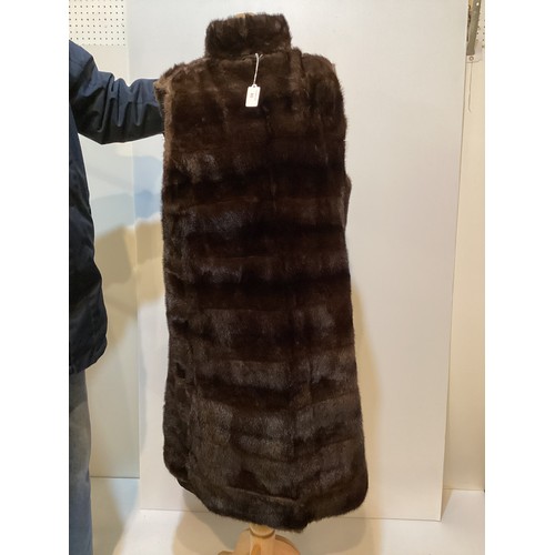 80 - A black fur lined raincoat, detachable lining, fur to collar and cuffs. No label.