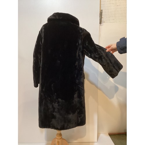 83 - A black 3/4 length fur coat with ornate buttons.