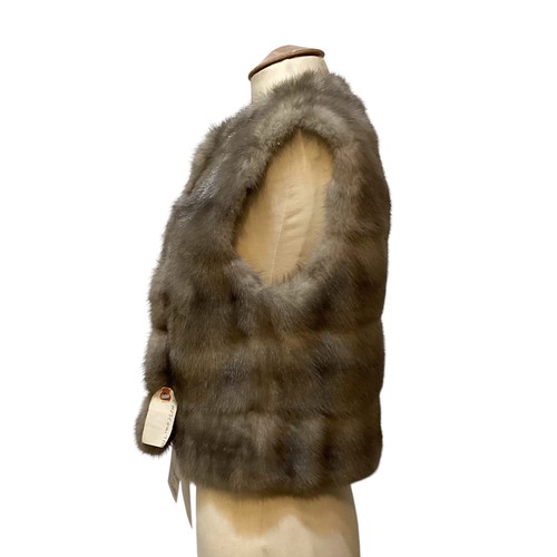 85 - A grey fur waistcoat with grey lining and leather buttons, label attached, 