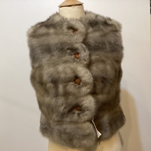 85 - A grey fur waistcoat with grey lining and leather buttons, label attached, 