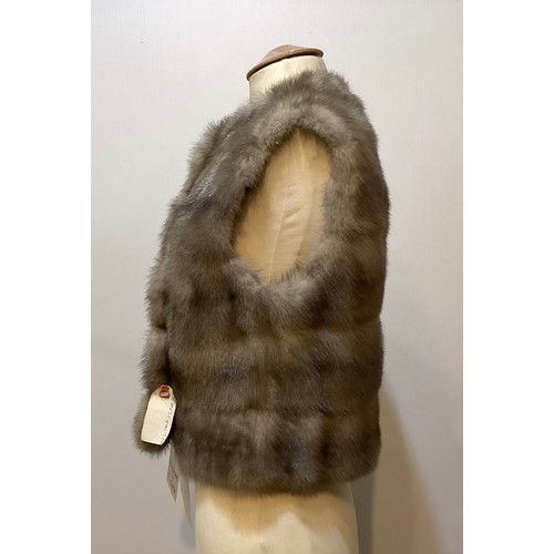 85 - A grey fur waistcoat with grey lining and leather buttons, label attached, 