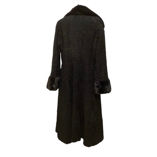 93 - A long, black Astrakhan coat with brown fur collar and cuffs, labelled SWAKARA. Condition, no sign o... 