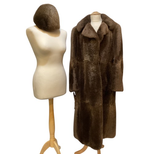 94 - A long brown beaver and mixed fiber coat with matching hat. 70's, condition: holes where label has b... 