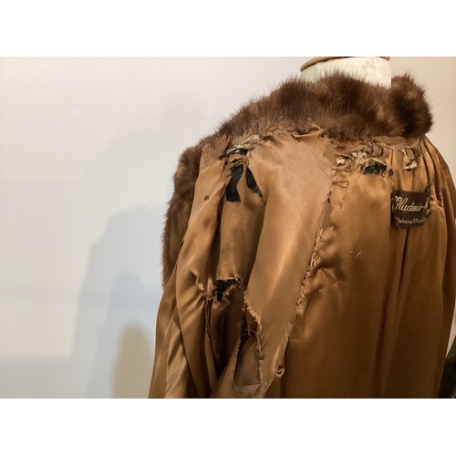 99 - A 3/4 length brown fur coat, labelled VLADIMIR OLISSOFF Condition: sign of wear and a split on shoul... 