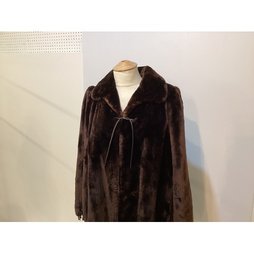 100 - Brown fur coat with leather fastenings. Condition, slight wear to cuffs and hem.