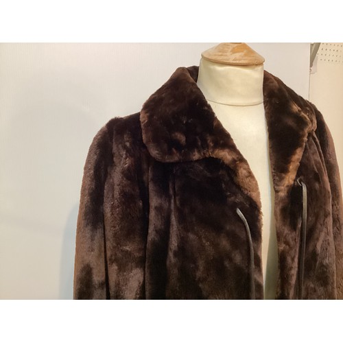 100 - Brown fur coat with leather fastenings. Condition, slight wear to cuffs and hem.