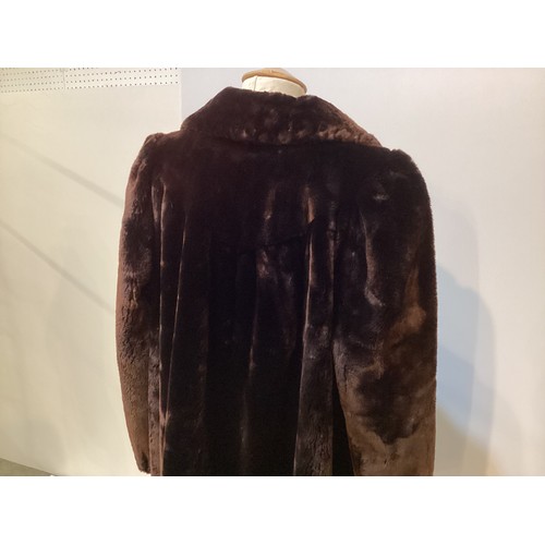 100 - Brown fur coat with leather fastenings. Condition, slight wear to cuffs and hem.