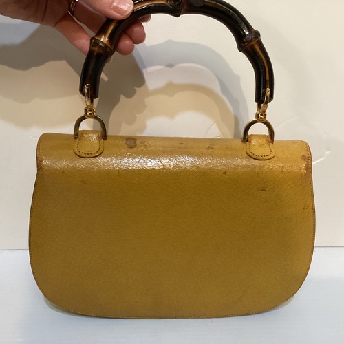 71 - Two GUCCI leather handbags with bamboo handle and fastening. Yellow with Gucci metal zip pull and nu... 