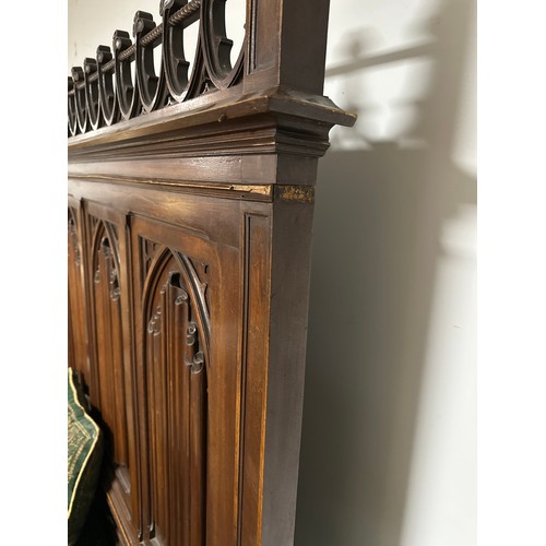 600 - A large gothic style high backed bench, with rising lid seat, and four decorative arched panels to b... 