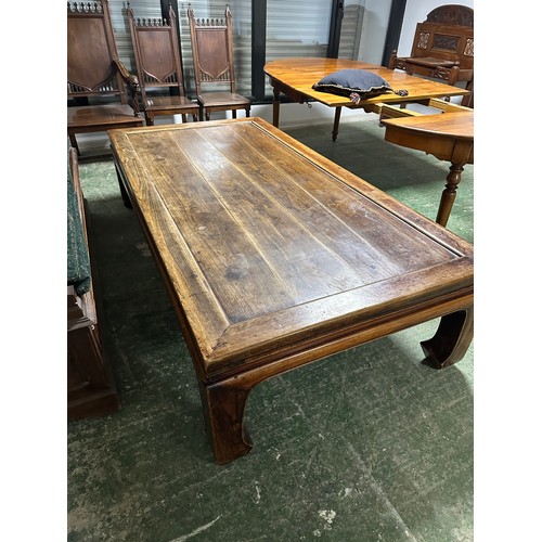 602 - A large low wooden coffee table in the oriental taste, 217cm long x 110c, wide x 54cm high, conditio... 