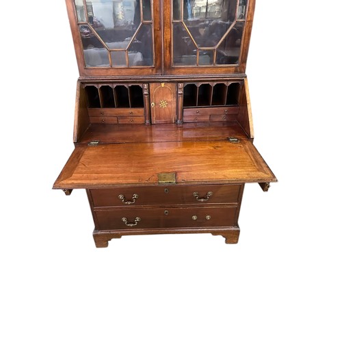 640 - A George III mahogany bureau bookcase, the fall front revealing fitted interior, over 4 long graduat... 