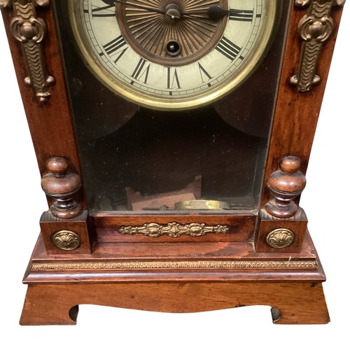 404 - A mahogany mantle clock with broken arch pediment, and brass mounts and a brass circular dial with b... 