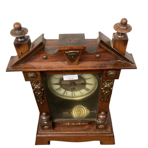 404 - A mahogany mantle clock with broken arch pediment, and brass mounts and a brass circular dial with b... 