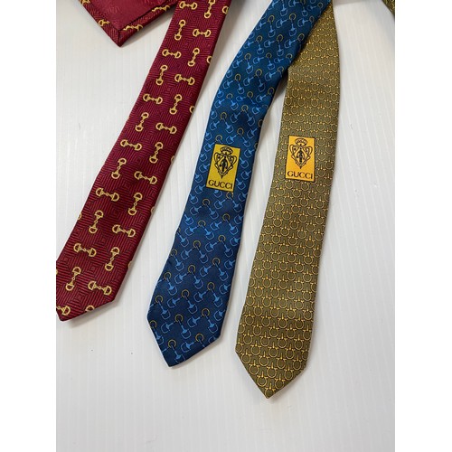 234 - Three Gucci silk ties. Red back ground with tradition horse bit gold pattern, blue back ground with ... 