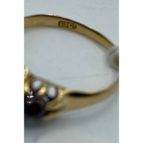 278 - An 18ct gold and red garnet three stone ring, size Q, 2.9g