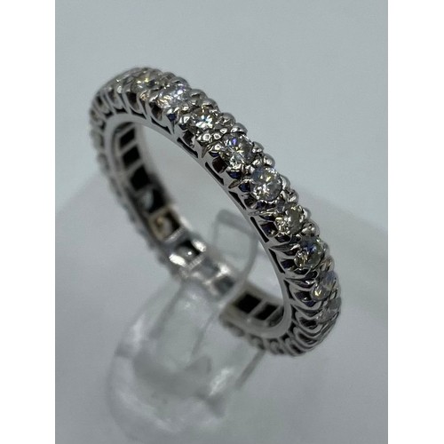 288 - An unmarked white metal full eternity ring, and an unmarked yellow metal dress ring, 9.4g