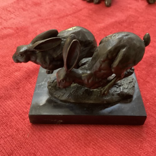 486 - A collection of bronze and composite resin models of animals.Otter, rabbits and hares.