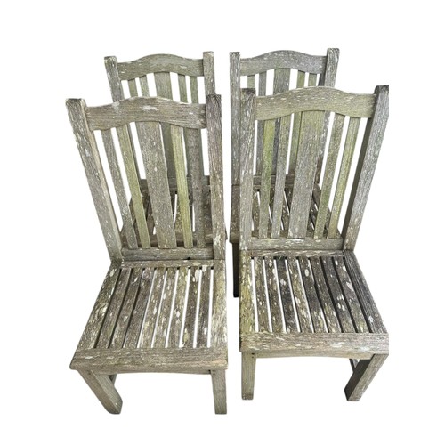 652 - A weathered teak garden table and four chairs