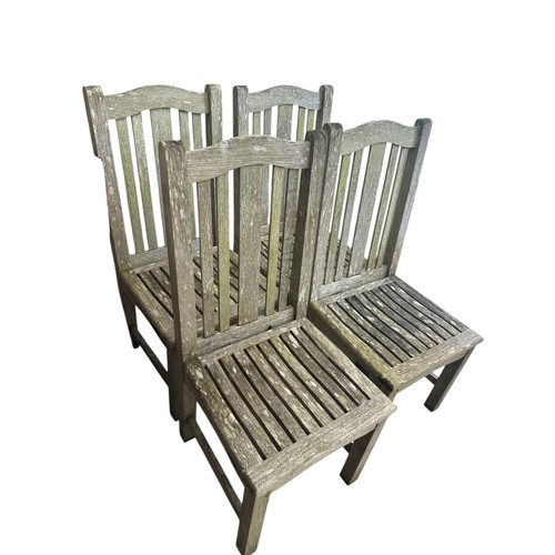 652 - A weathered teak garden table and four chairs