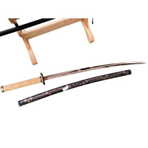 496 - Two samurai style swords on stand with one other.