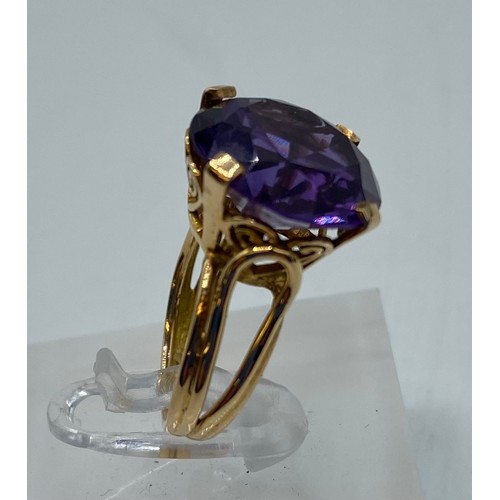 309 - A large yellow metal Amethyst dress ring. Hallmarks worn possibly 14ct gold. Size H. 5.9g