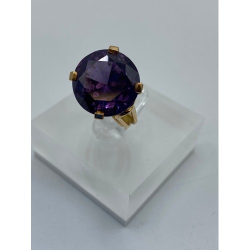 309 - A large yellow metal Amethyst dress ring. Hallmarks worn possibly 14ct gold. Size H. 5.9g