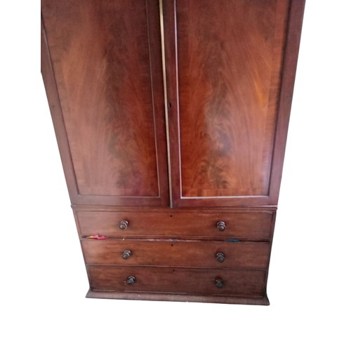 637 - A mahogany linen press with cupboard above and brass hanging rail and three drawers to base, 130 cm ... 