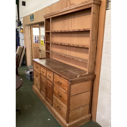 649 - A rustic pine pine kitchen dresser with 8 drawers and cupboard to base below a plate rack