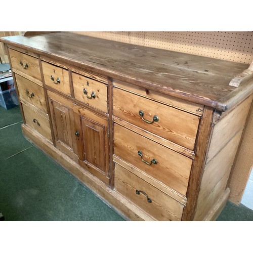 649 - A rustic pine pine kitchen dresser with 8 drawers and cupboard to base below a plate rack