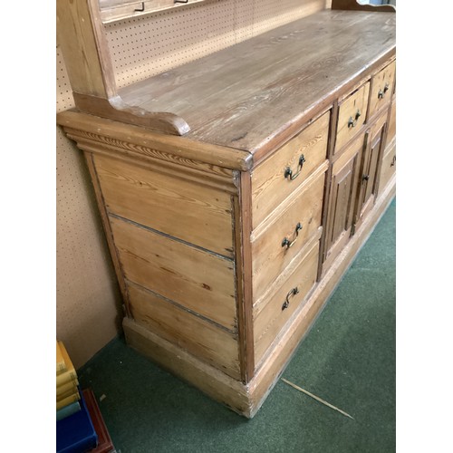 649 - A rustic pine pine kitchen dresser with 8 drawers and cupboard to base below a plate rack