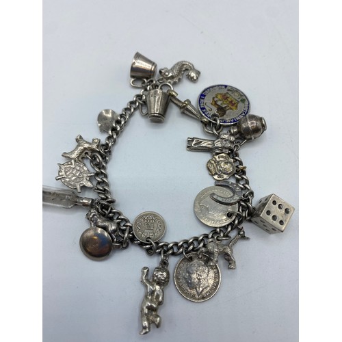 269 - A sterling silver charm bracelet set with numerous sterling silver charms, 50g