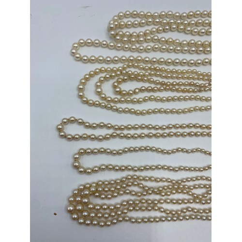 306 - Six pearl necklaces, to include a graduated three row with 9ct gold circular pearl and purple six st... 