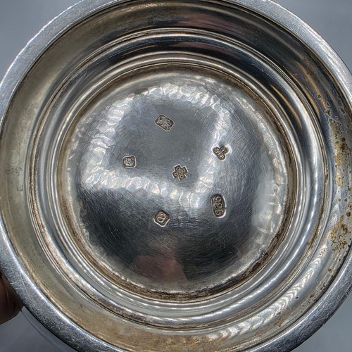 4 - A large Sterling silver hand planished water jug with cast scrolling handle on circular stepped foot... 