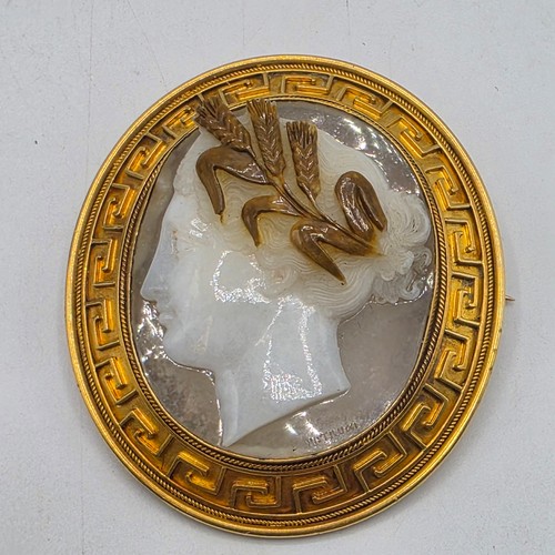 3 - Elena Pistrucci (1822-1886) An unmarked yellow metal hardstone cameo brooch with Greek key oval surr... 