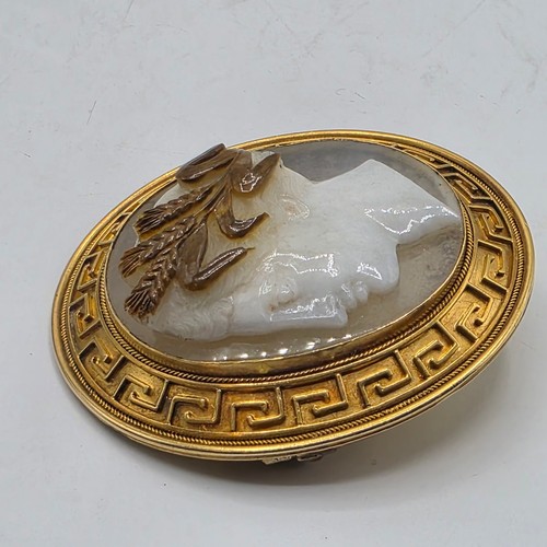 3 - Elena Pistrucci (1822-1886) An unmarked yellow metal hardstone cameo brooch with Greek key oval surr... 
